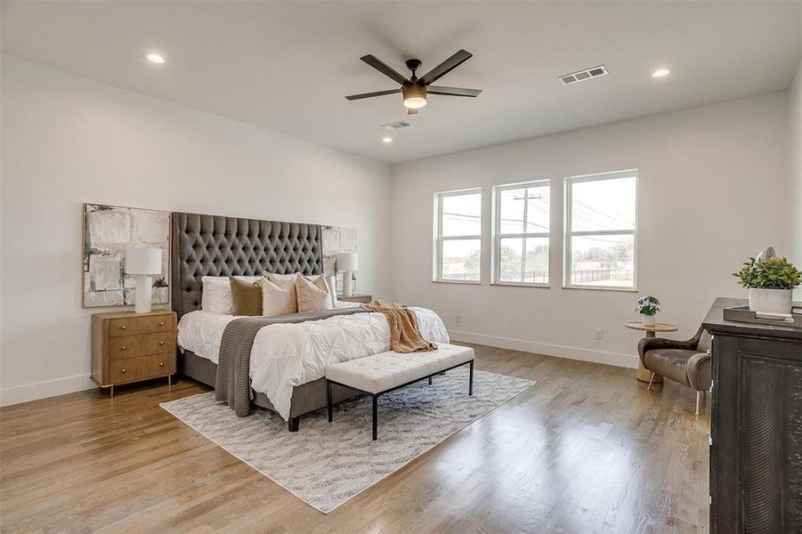 Bedroom with light wood-type flooring, visible vents, baseboards, and recessed lighting