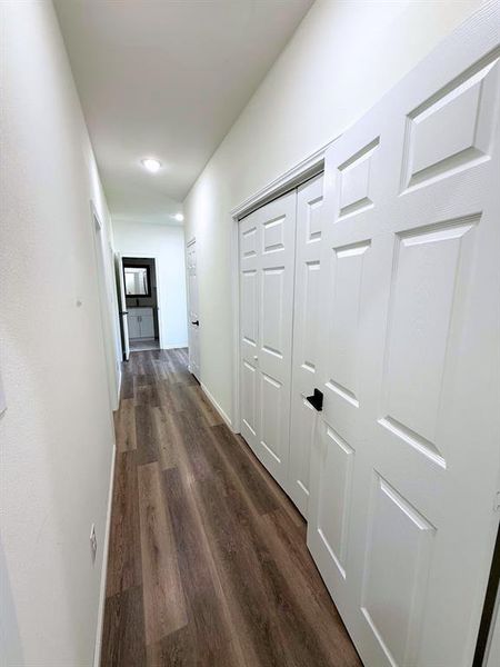 Hall with dark wood-style flooring and baseboards