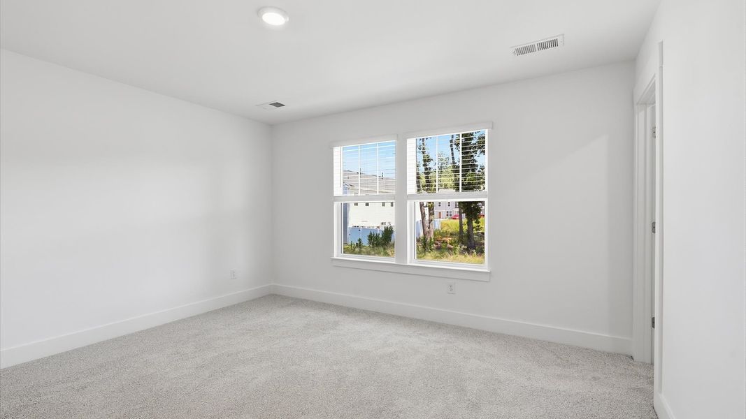 Vibrant natural light fills this exceptional primary suite with eye-catching details at Clarke Townes