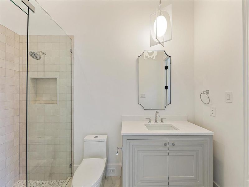 Bathroom with vanity, toilet, and a shower with door