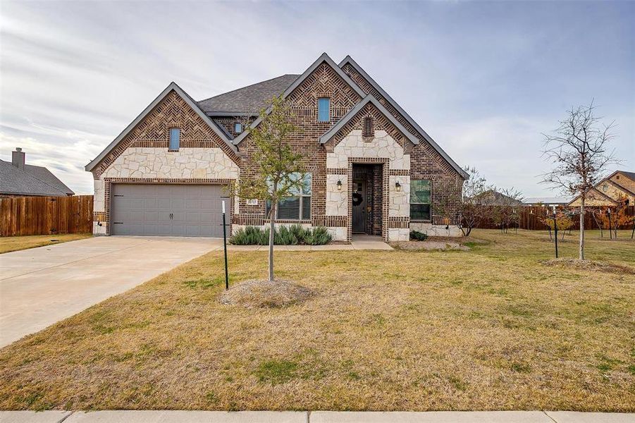 View of front of home featuring a garage and a front yard