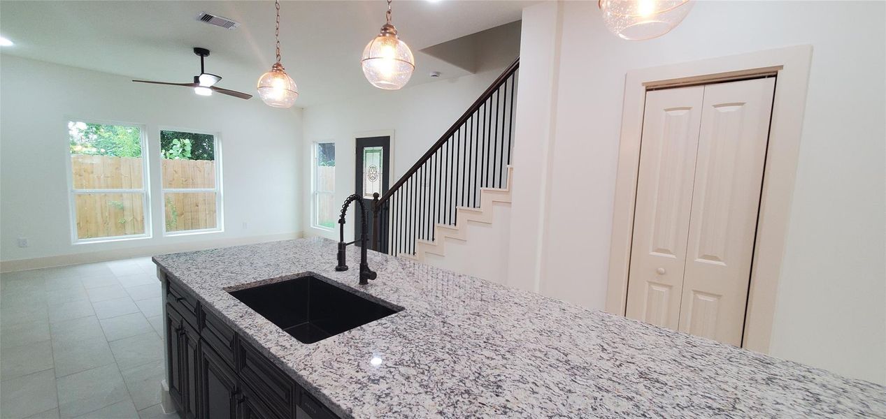 Kitchen with a 10-foot island for seating with plenty of seating for family and friends. Also has a supply closet under the staircase.