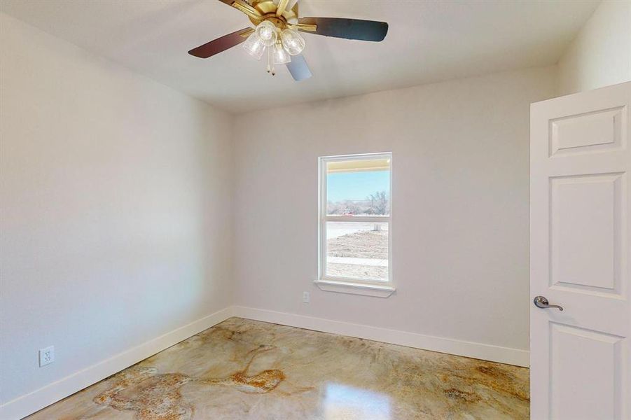 Spare room featuring concrete floors and ceiling fan