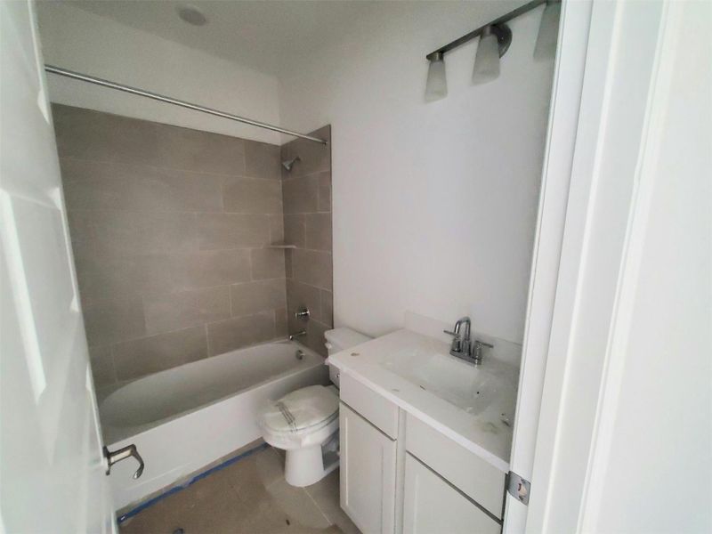 Bathroom featuring vanity, toilet, and shower / washtub combination