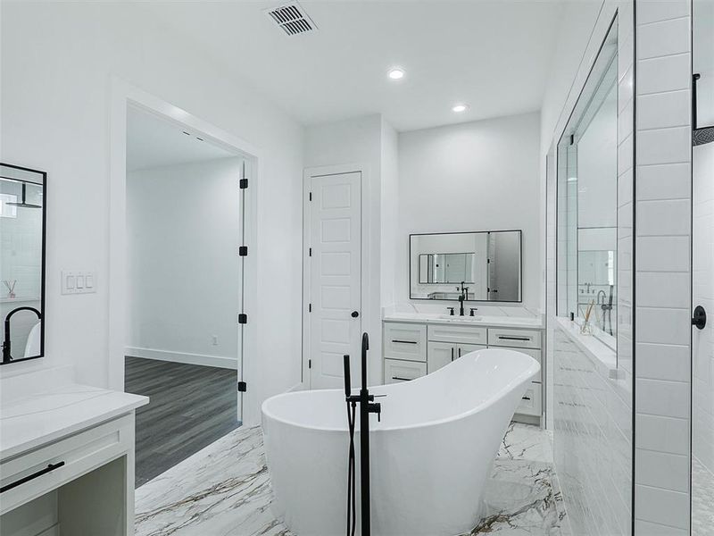 The ensuite bathroom includes a freestanding soaking tub, Roman-style walk-in shower, and dual vanities with quartz countertops.