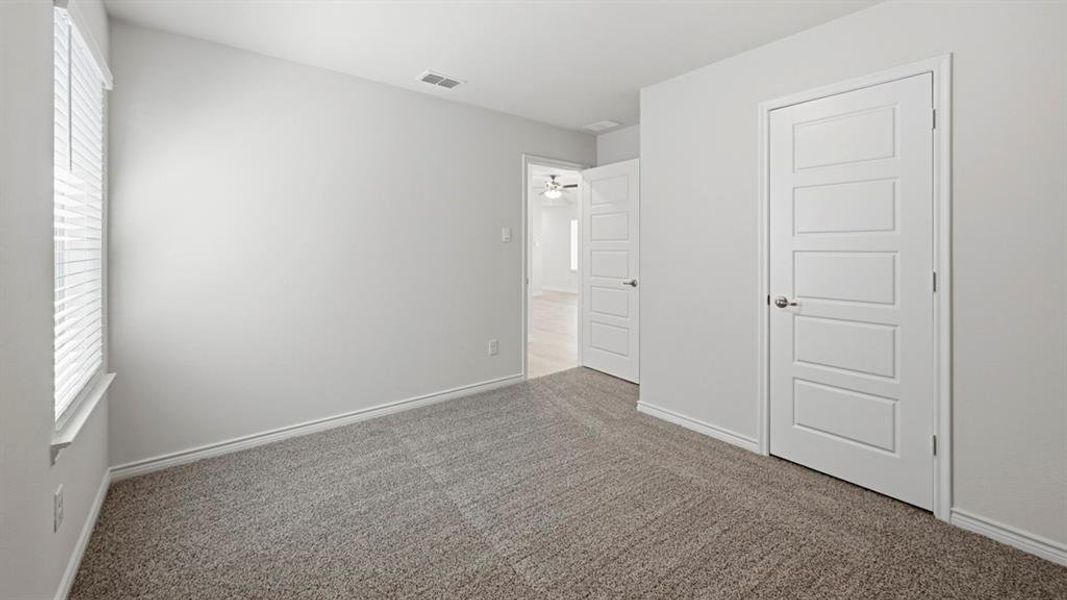 Unfurnished bedroom featuring multiple windows and carpet floors