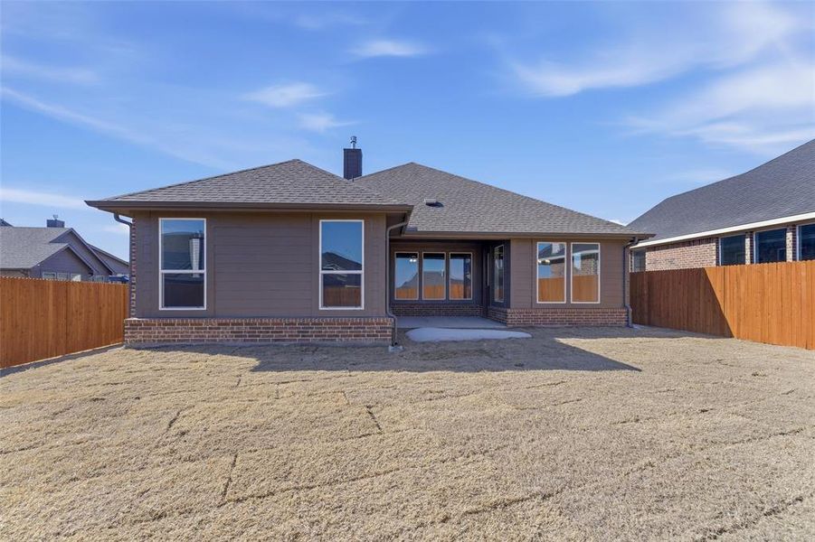Back of house featuring a fenced backyard, a patio area, a chimney, and roof with shingles