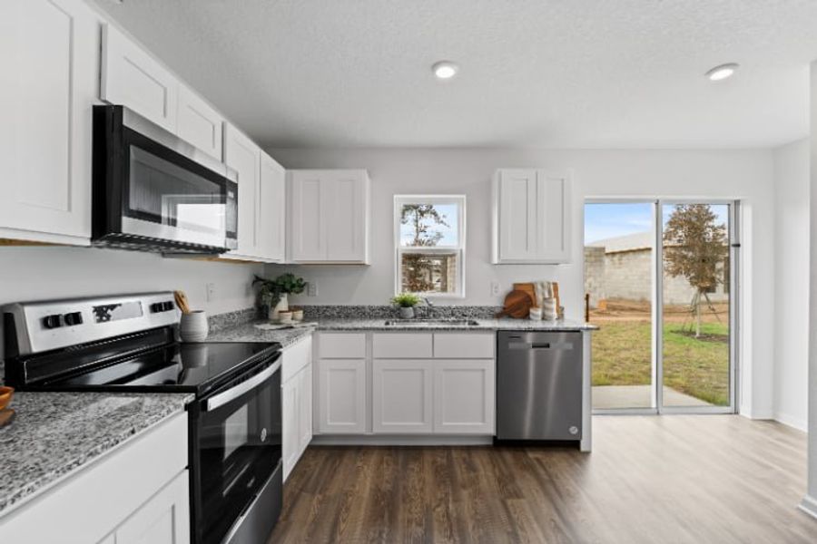 A kitchen with white cabinets.