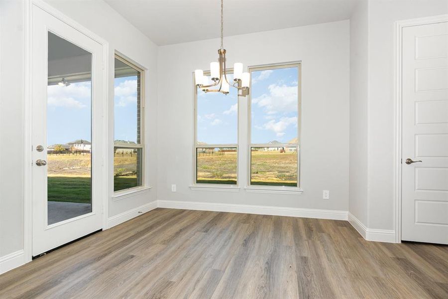 Unfurnished dining area featuring a chandelier and light wood-style floors
