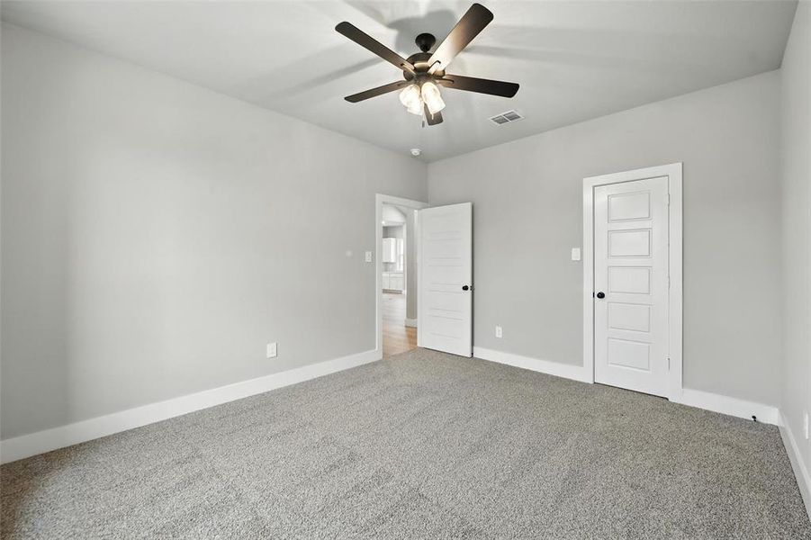 Unfurnished bedroom with carpet flooring and ceiling fan Unfurnished bedroom with carpet flooring and ceiling fan