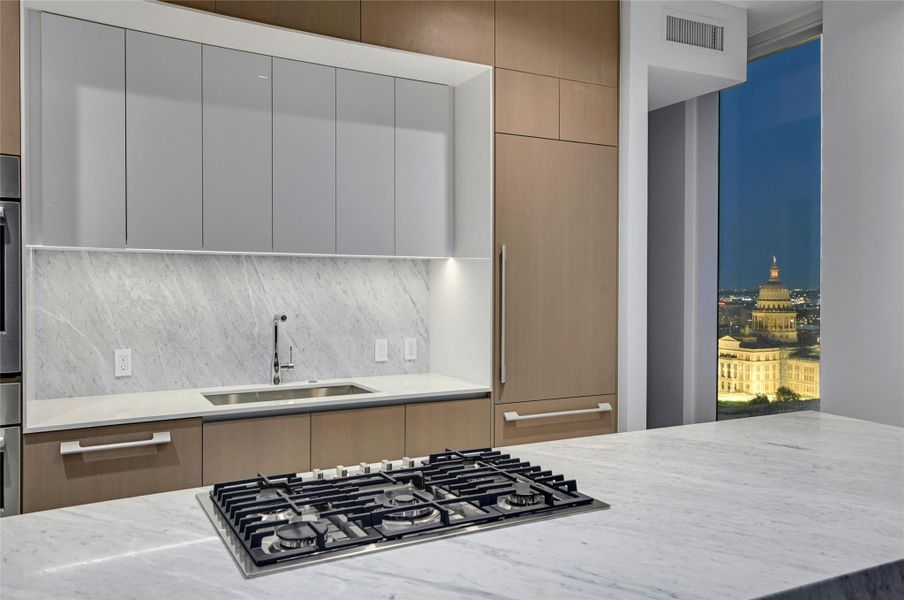 Kitchen with modern cabinets, stainless steel gas cooktop, a sink, and tasteful backsplash Kitchen with modern cabinets, stainless steel gas cooktop, a sink, and tasteful backsplash