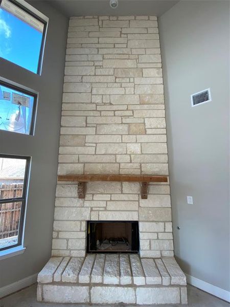 Austin Chalk raised hearth gas fireplace with stained cedar mantle.