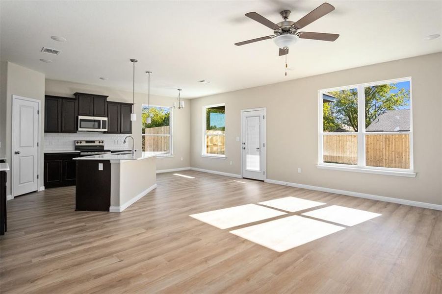 Kitchen featuring stainless steel appliances, open floor plan, an island with sink, and healthy amount of natural light Kitchen featuring stainless steel appliances, open floor plan, an island with sink, and healthy amount of natural light