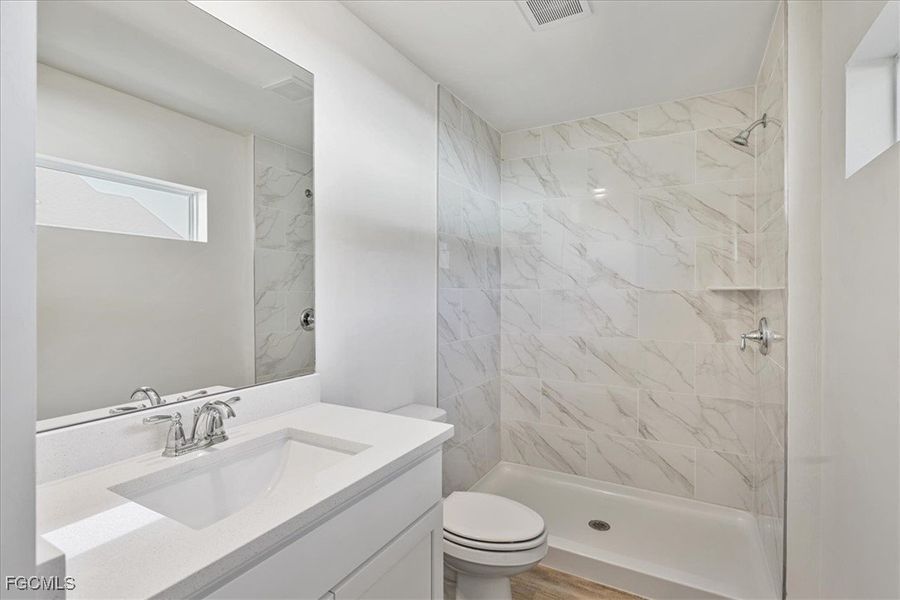 Bathroom featuring vanity, a stall shower, and light wood finished floors