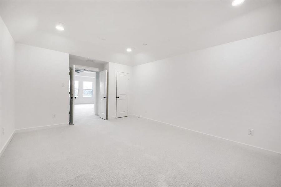 Spacious room featuring light-colored carpeting and recessed ceiling lighting