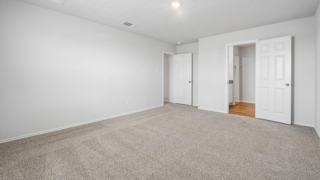 A spacious, naturally illuminated room boasts plush carpeting, ideal for tranquil relaxation.