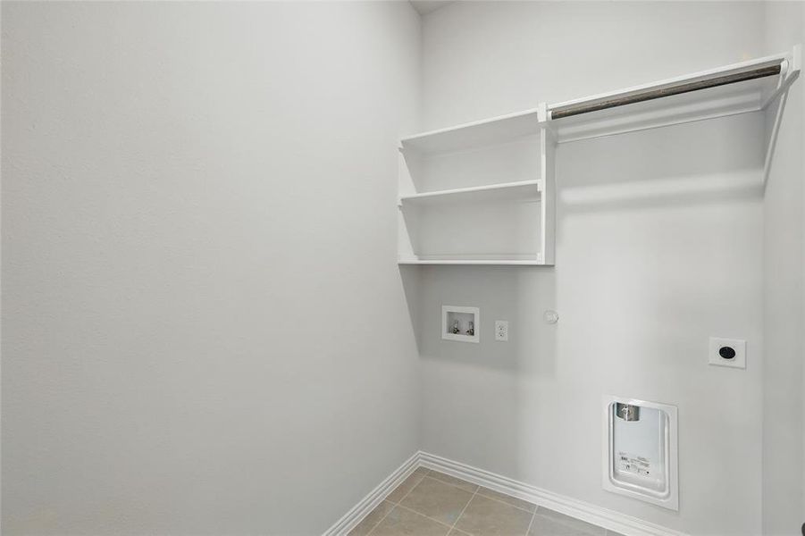 Laundry room with hookup for an electric dryer, baseboards, washer hookup, hookup for a gas dryer, and light tile patterned flooring Laundry room with hookup for an electric dryer, baseboards, washer hookup, hookup for a gas dryer, and light tile patterned flooring