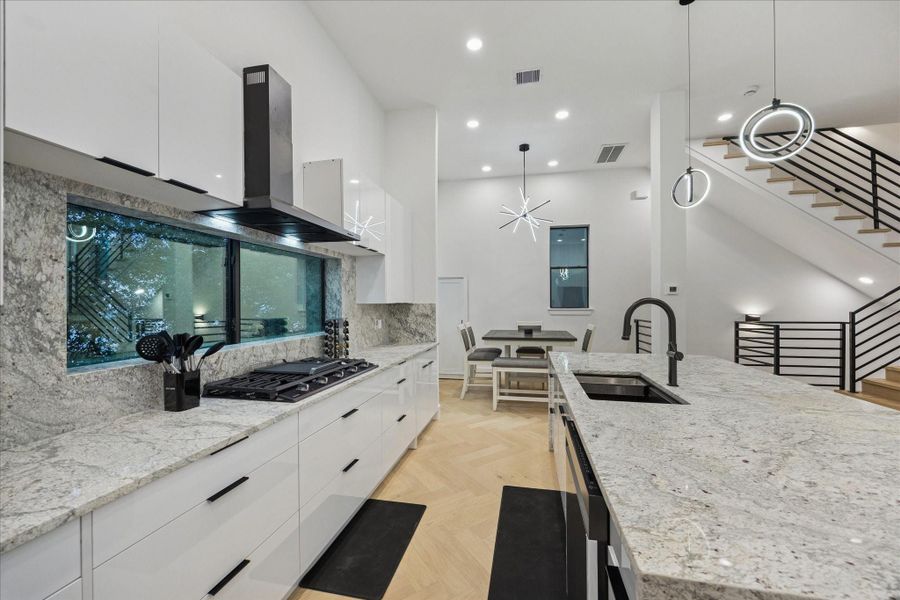 Chef-inspired kitchen featuring expansive granite countertops, an oversized island with seating, soft-close cabinetry and drawers, and premium finishes designed for everyday living and effortless entertaining.
