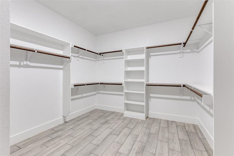 Spacious closet with light hardwood / wood-style floors