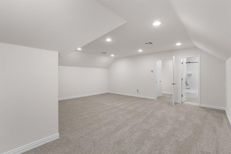 Additional living space featuring vaulted ceiling, light colored carpet, and recessed lighting Additional living space featuring vaulted ceiling, light colored carpet, and recessed lighting