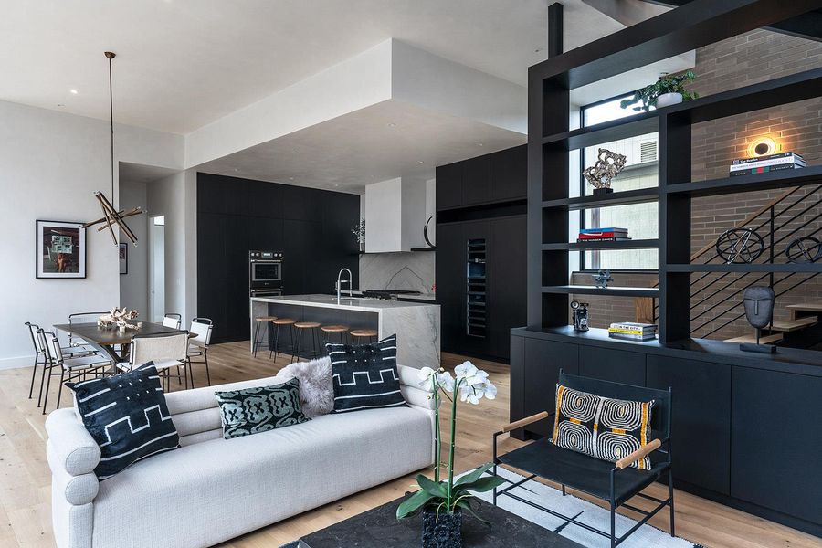 An open-concept living space with sleek, dark cabinetry and light wood flooring. An open-concept living space with sleek, dark cabinetry and light wood flooring.