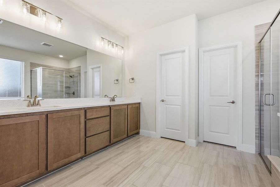 master Bathroom featuring a double vanity with wood-finish cabinetry, Granite countertops, dual undermount sinks with walkin shower and garden tub