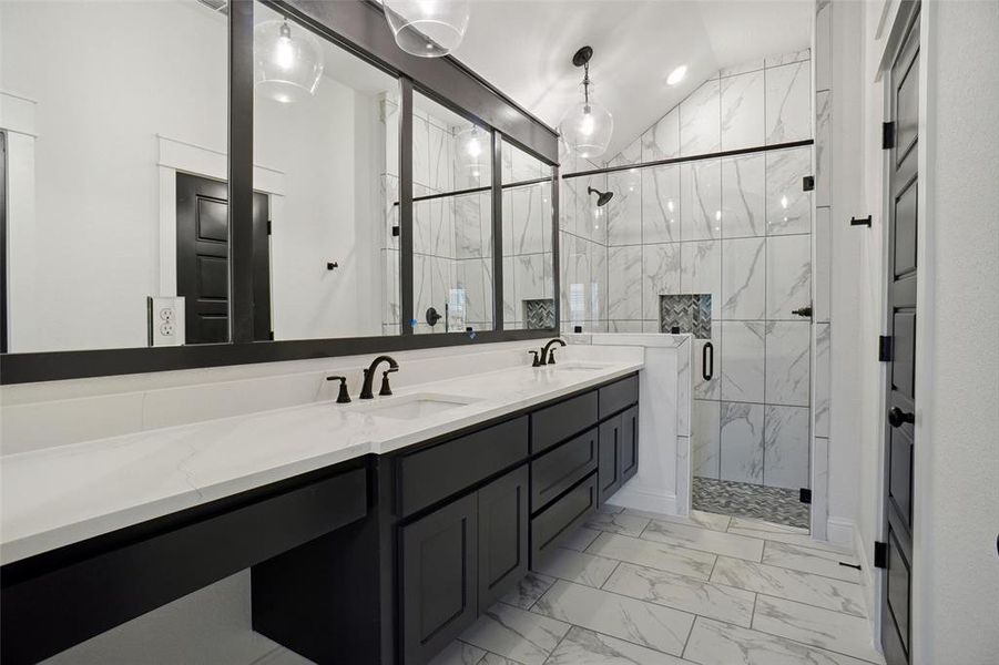 Bathroom featuring lofted ceiling, tile patterned floors, a shower with door, and dual bowl vanity