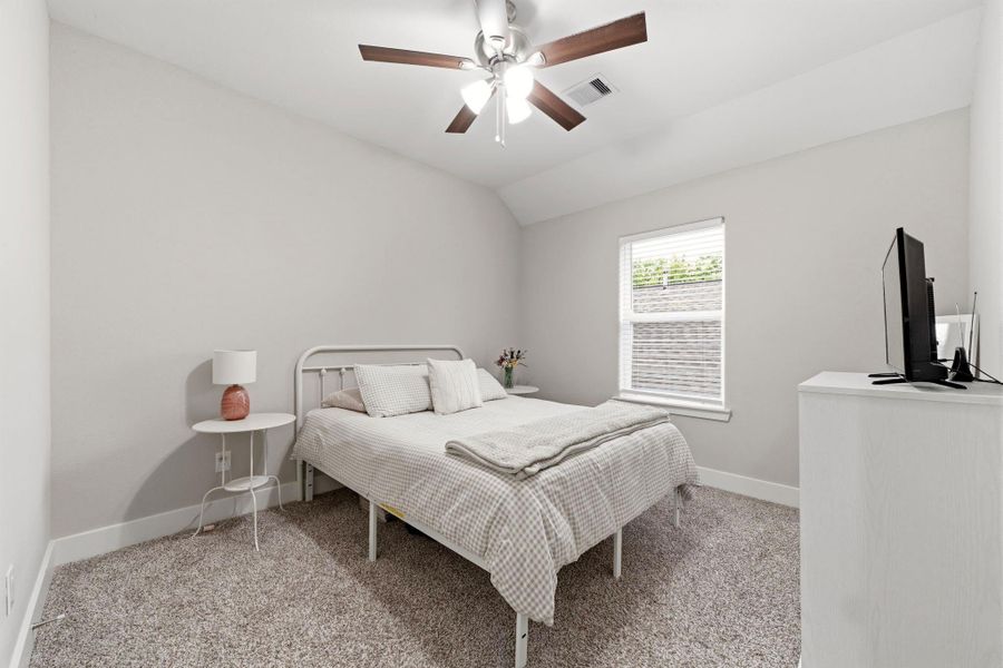 Spacious secondary bedroom features plush carpet, generous closet space, and ceiling fan for year round comfort.