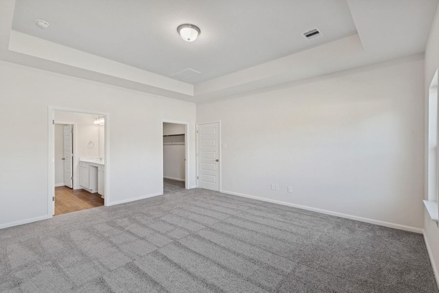 The Crawford- Primary Suite with Tray Ceiling. Home under construction, photo used for illustrative purposes only, colors and options will vary.