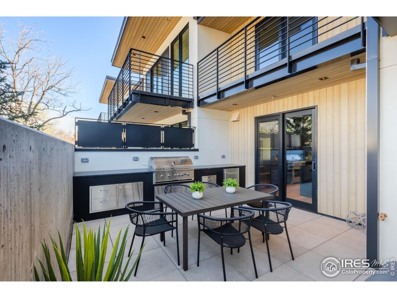 The outdoor kitchen comes equipped with a built-in gas range, fridge, stainless steel cabinets and the continuation of the soapstone countertop from the indoor kitchen for elegant meal preparation and entertaining.