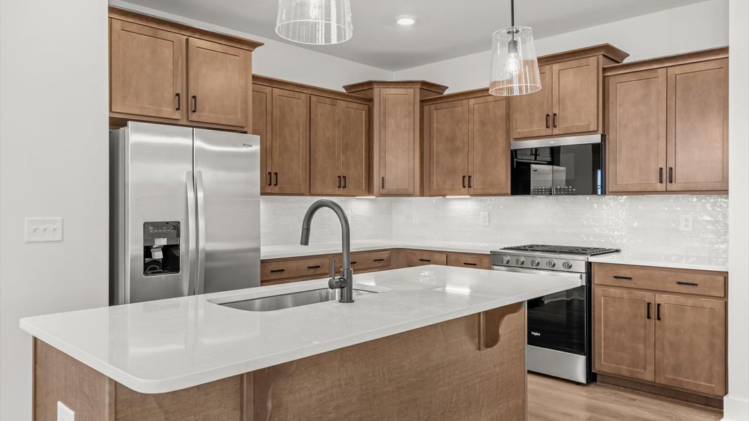 Highly skilled craftsmanship shines in this modern kitchen with pendant lighting and a central island focal point