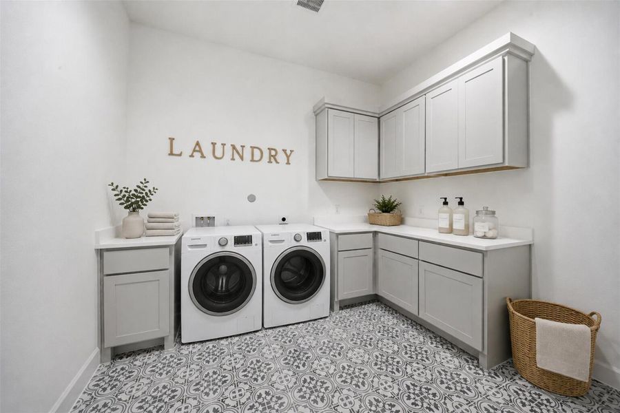 **Virtually Staged** Spacious laundry room thoughtfully designed with extensive custom cabinetry, abundant counter space, designer patterned tile flooring, and functionality that blends everyday convenience with elevated style.