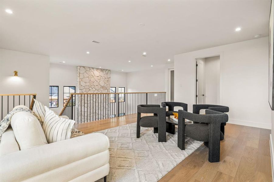 Living area with light wood-style flooring and recessed lighting Living area with light wood-style flooring and recessed lighting