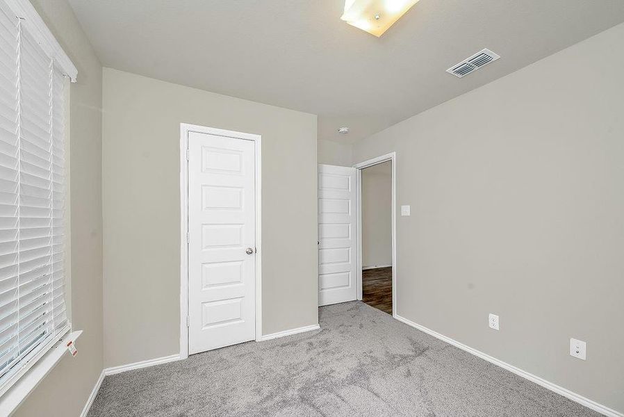 Unfurnished bedroom with light colored carpet and a closet