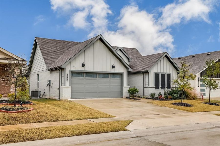 Modern farmhouse style home featuring board and batten siding, roof with shingles, brick siding, driveway, and a garage Modern farmhouse style home featuring board and batten siding, roof with shingles, brick siding, driveway, and a garage