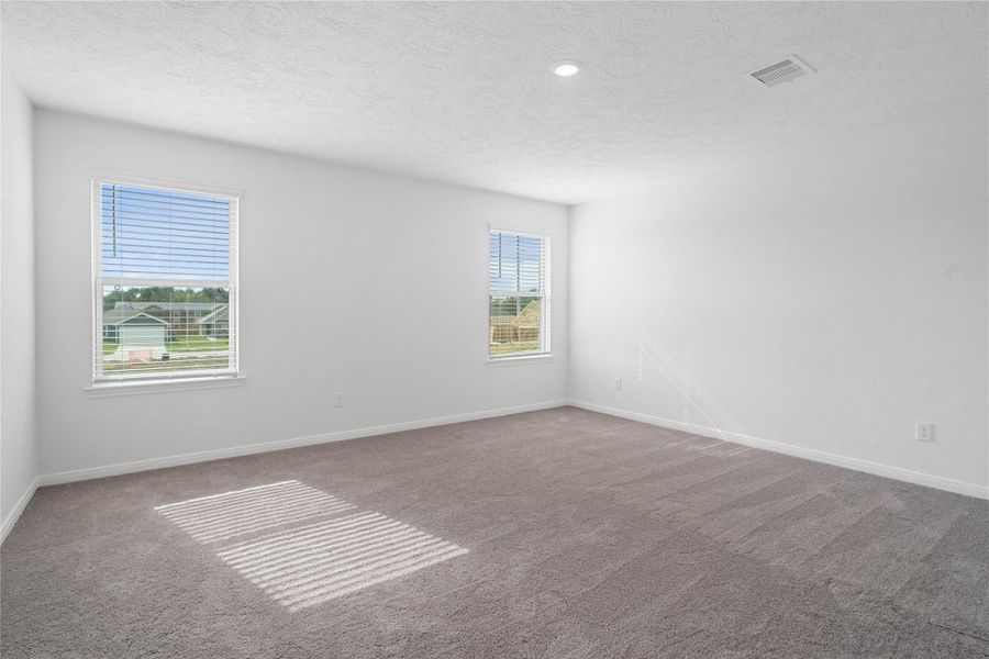 Relax and recharge in this stunning primary suite! Enjoy the comfort of plush carpeting, neutral-toned walls, high ceilings, recessed lighting, and large windows with privacy blinds that fill the room with natural light.
