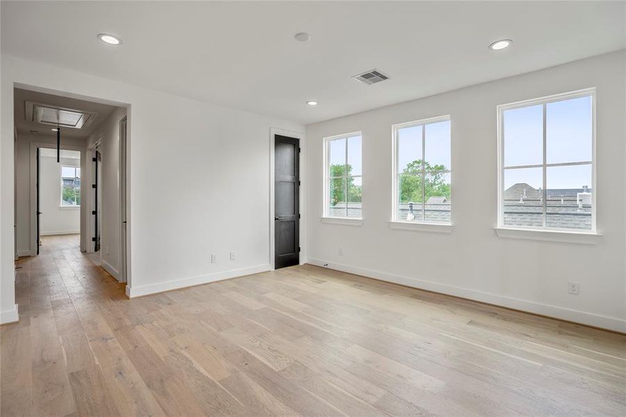 View of the third floor game room in relation to the hallway to an en-suite bedroom, powder bath, and the study.