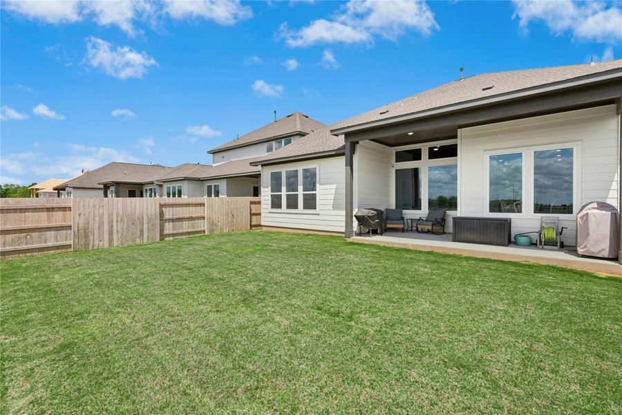 Rear view of house with a patio area, a fenced backyard