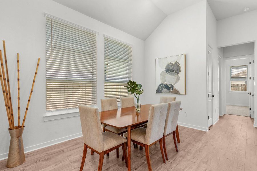 High vaulted ceilings and wood floors define this airy dining space.