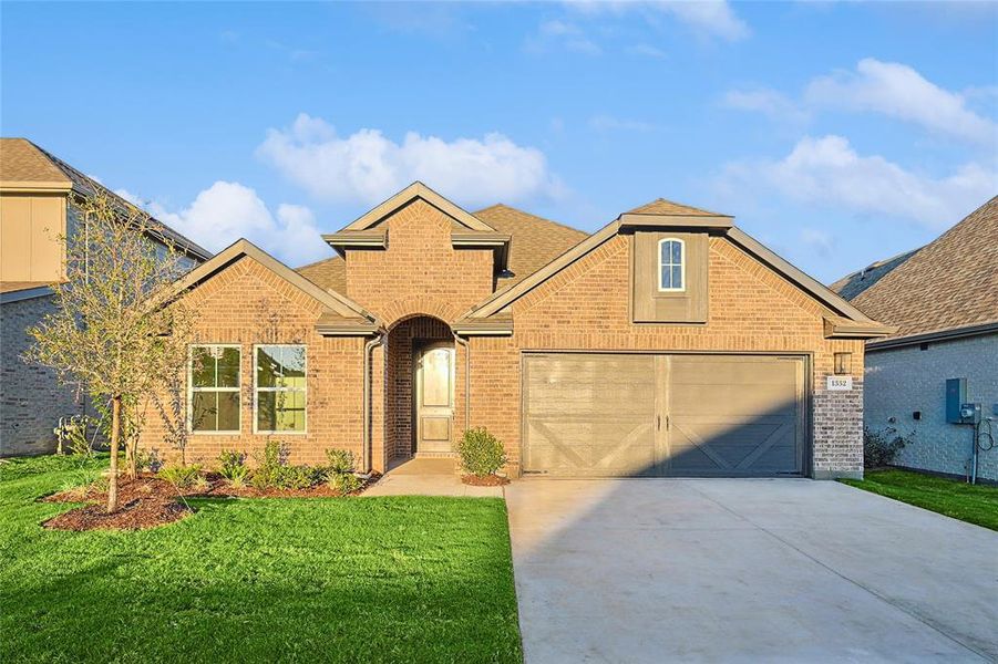 Front of property with a garage and a front lawn