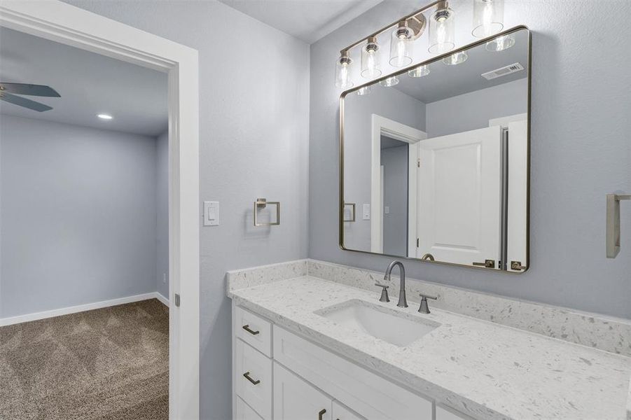 Bathroom with a ceiling fan and vanity
