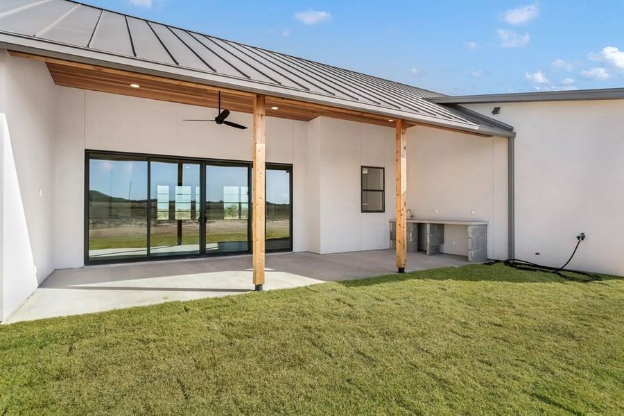 Back of house featuring a standing seam roof, a patio area, ceiling fan, and stucco siding Back of house featuring a standing seam roof, a patio area, ceiling fan, and stucco siding
