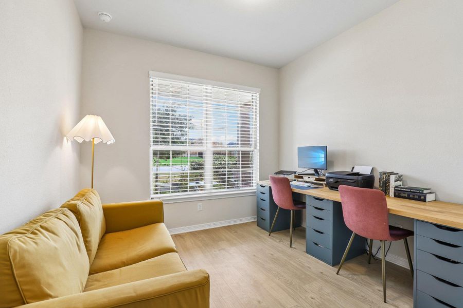 A quiet and bright room features durable flooring, ideal for a home office.