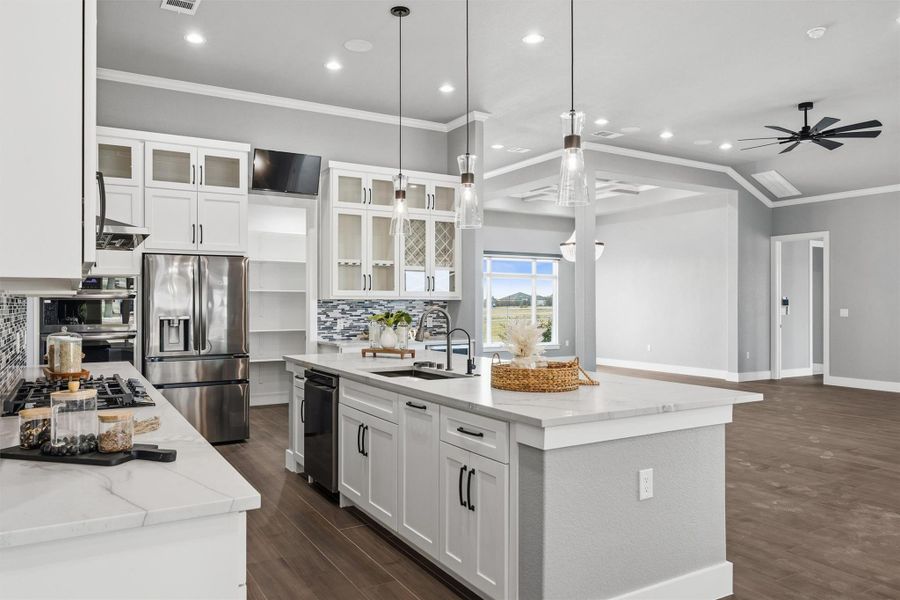 Kitchen featuring crown molding, glass fronted cabinets, white cabinets, stainless steel appliances, and light stone counters