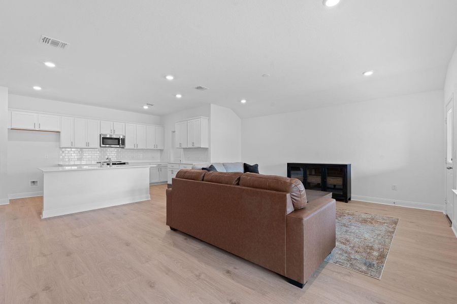 Living area with light wood-style floors and recessed lighting Living area with light wood-style floors and recessed lighting
