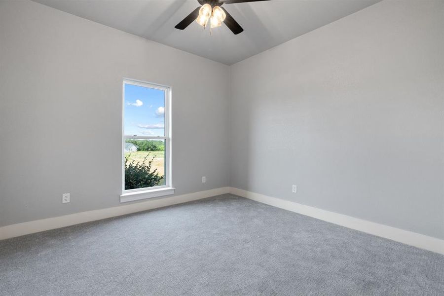 Empty room with healthy amount of natural light, a ceiling fan, and a chandelier