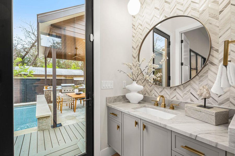 Bathroom with vanity, backsplash, and healthy amount of natural light