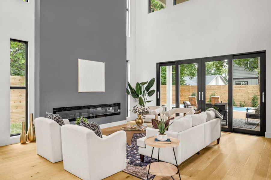 An airy living room with high ceilings flows seamlessly to a private outdoor oasis through expansive sliding doors. An airy living room with high ceilings flows seamlessly to a private outdoor oasis through expansive sliding doors.