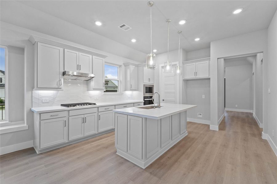 The stunning and generously sized breakfast bar is perfect for casual dining and entertaining. The elegant pendant lights and under cabinet lighting provides additional lighting and refined style.