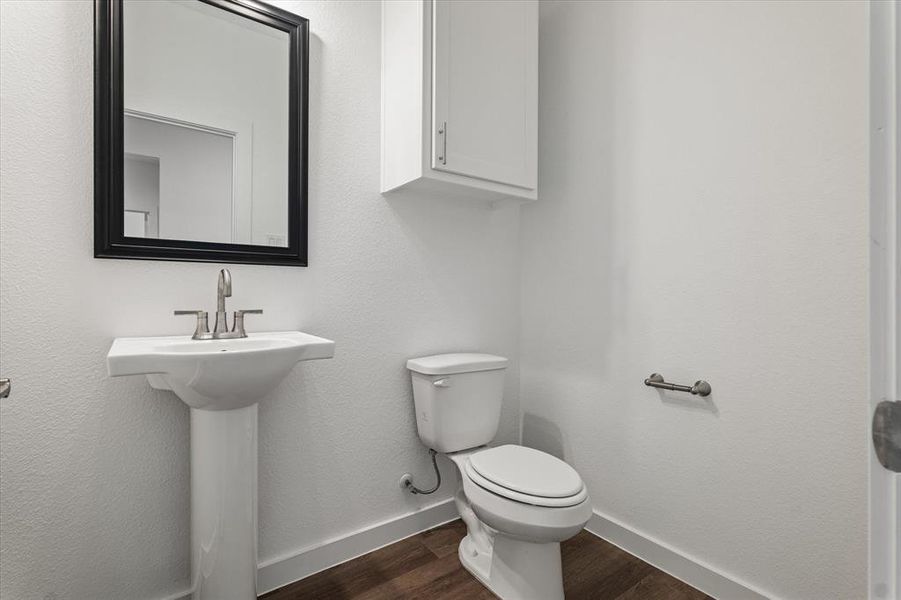 Bathroom featuring hardwood / wood-style floors, toilet, and sink